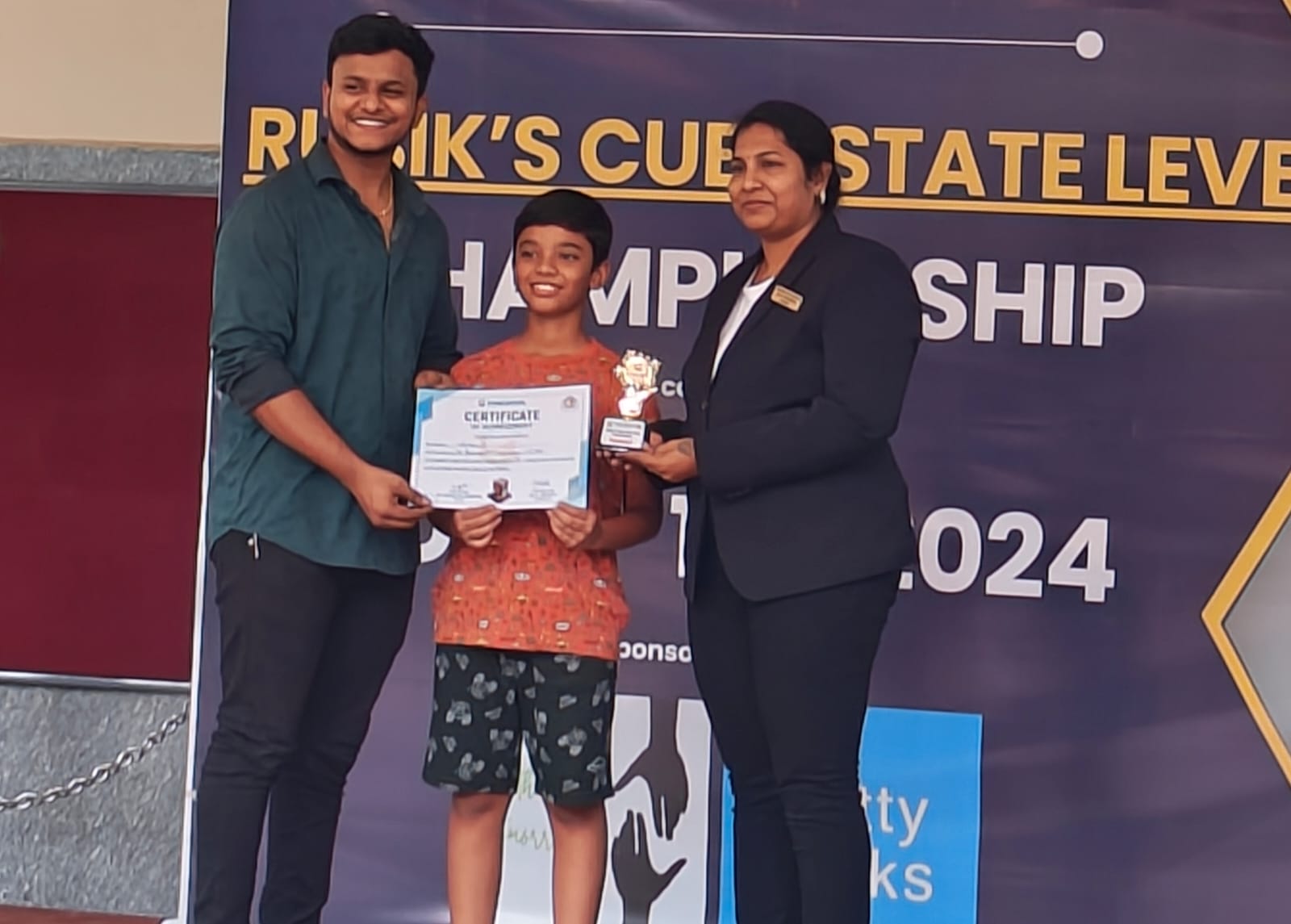 Arjun holding his trophy and certificate